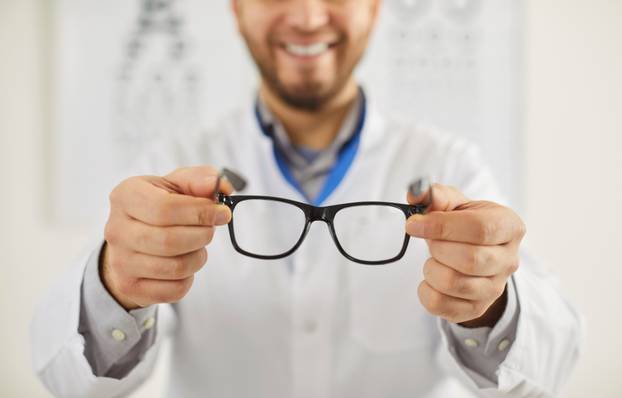 Man,Professional,Ophtalmologist,Holding,Spectacles,With,Corrective,Lenses,,Taking,Care