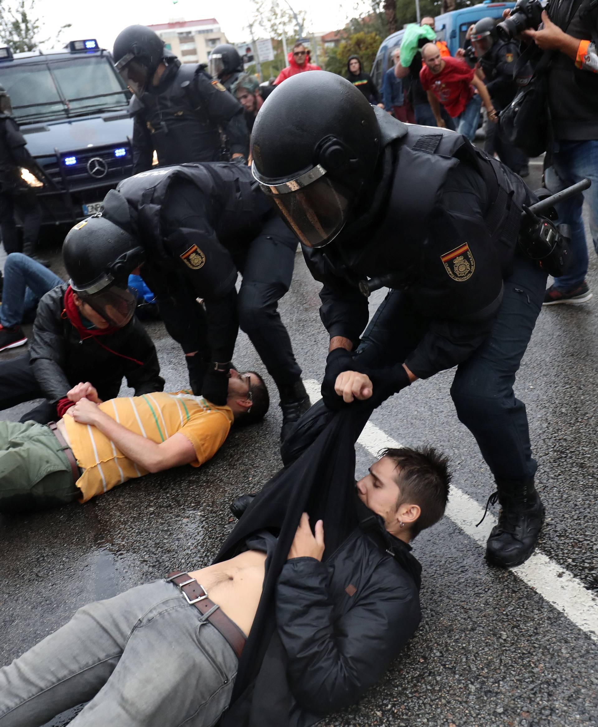 Spanish Civil Guard officers remove demonstrators outside a polling station for the banned independence referendum in Barcelona