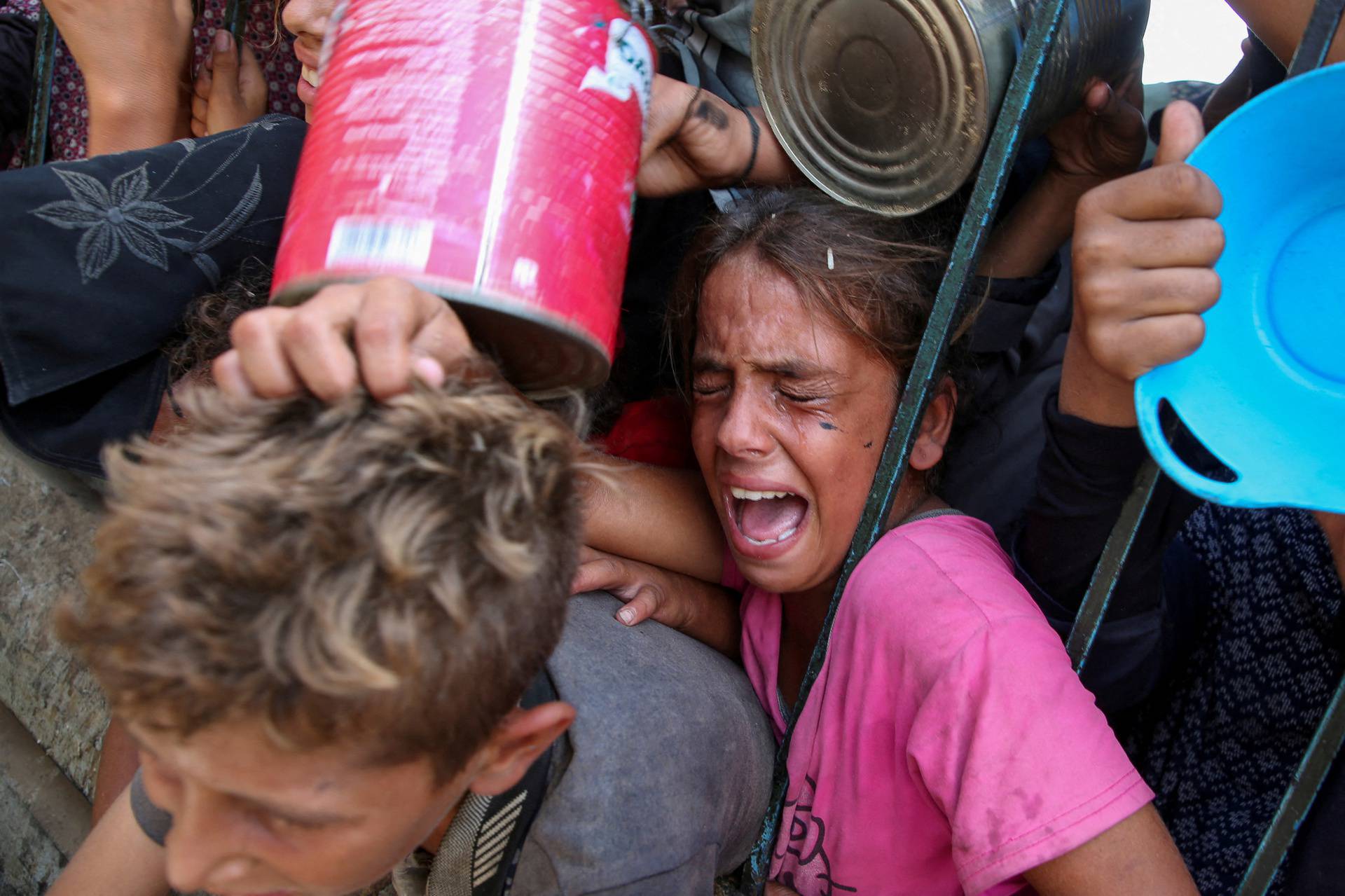 FILE PHOTO: Palestinians gather to receive food cooked by a charity kitchen, amid the Israel-Hamas conflict, in Khan Younis, southern Gaza Strip