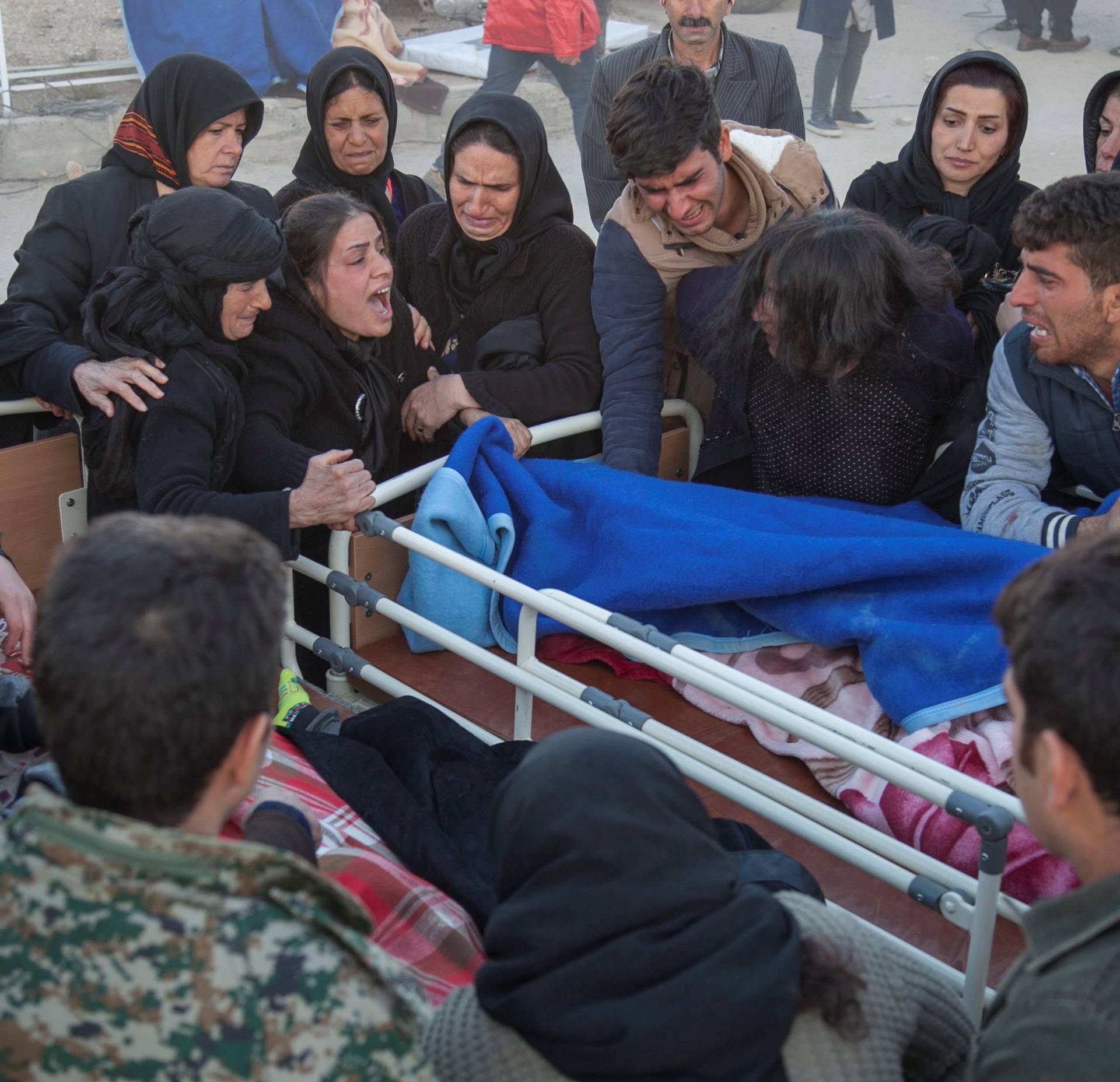 People react next to a dead body following an earthquake in Sarpol-e Zahab county in Kermanshah