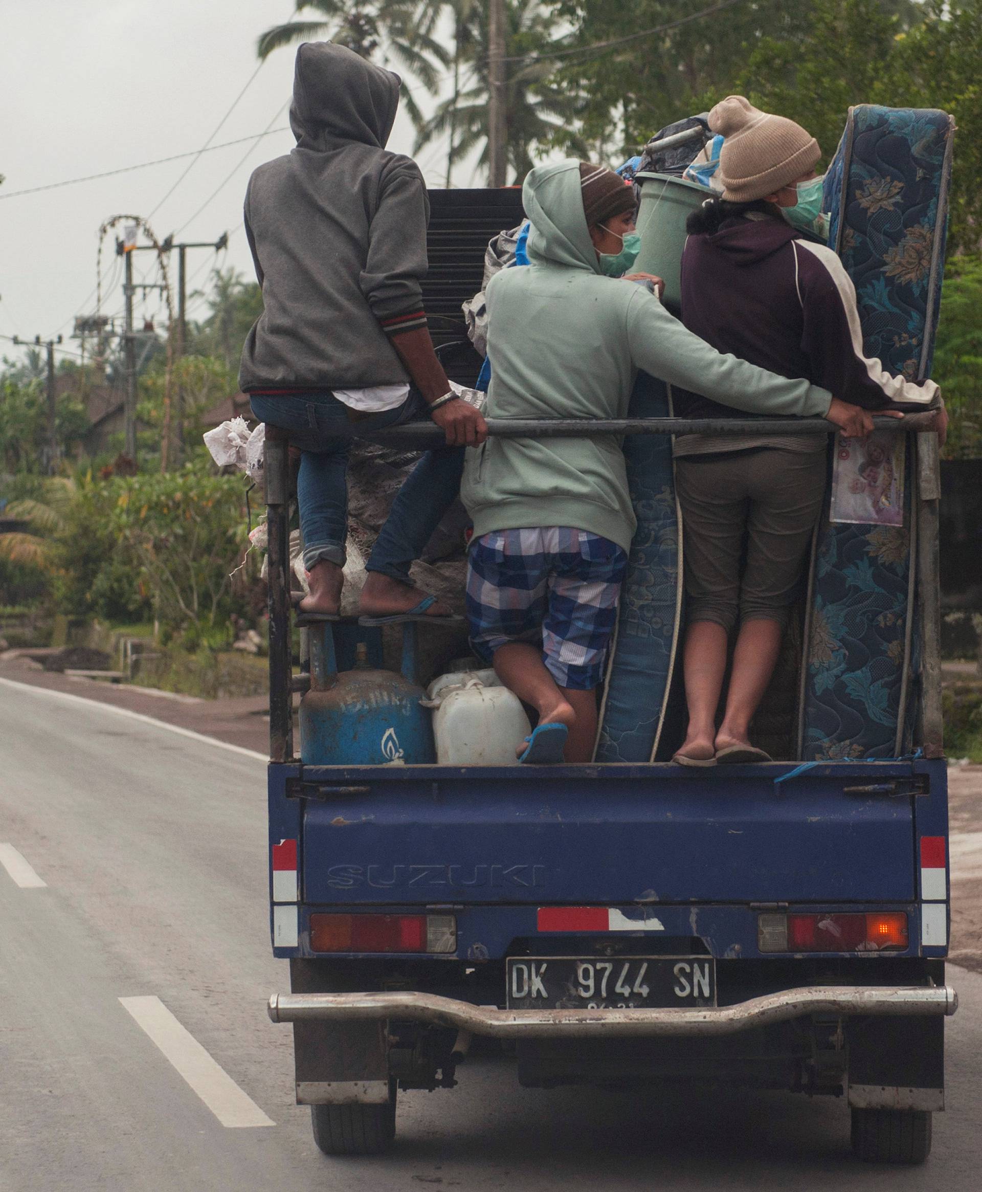 Villagers sit on top of a truck as they are moving to the temporary shelter at Rendang village in Karangasem