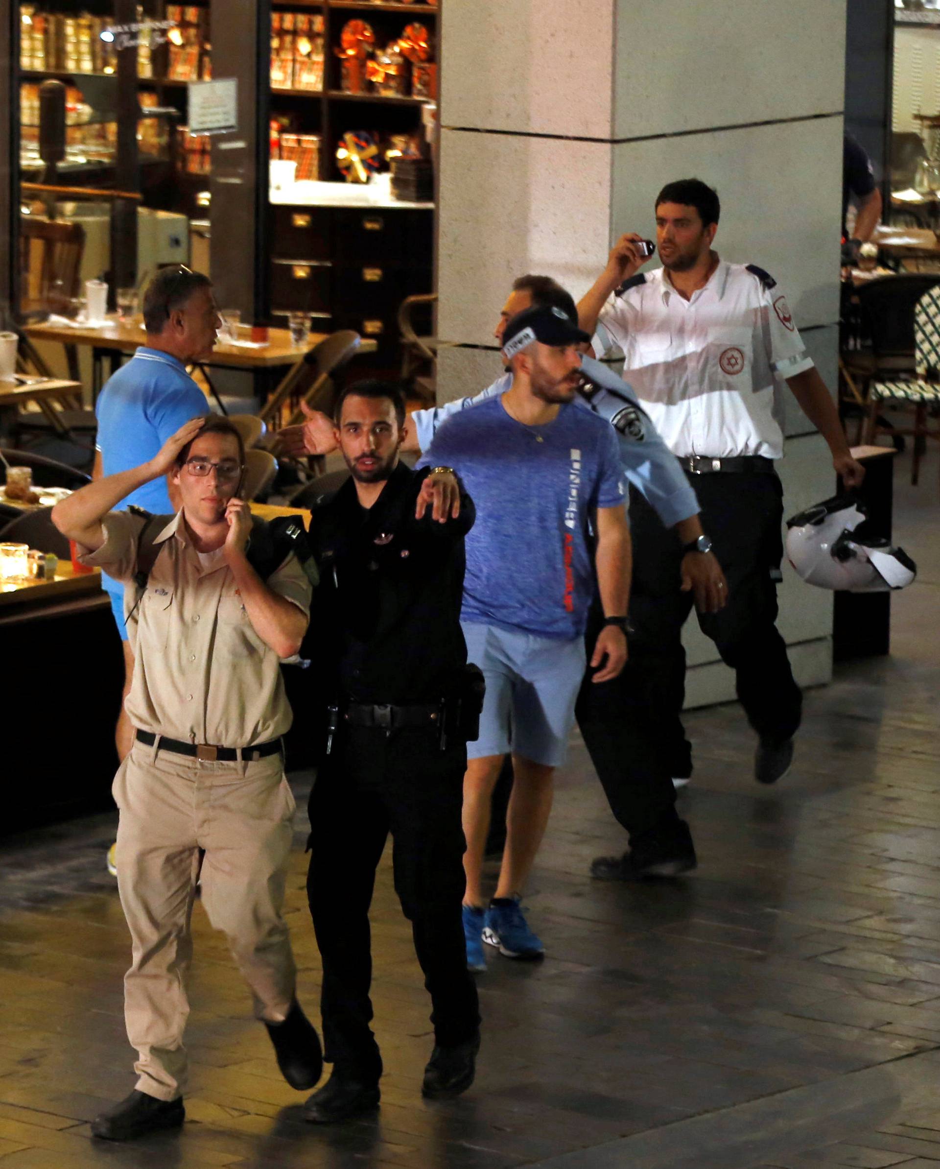 An Israeli policeman clears the area after a shooting attack took place in the center of Tel Aviv