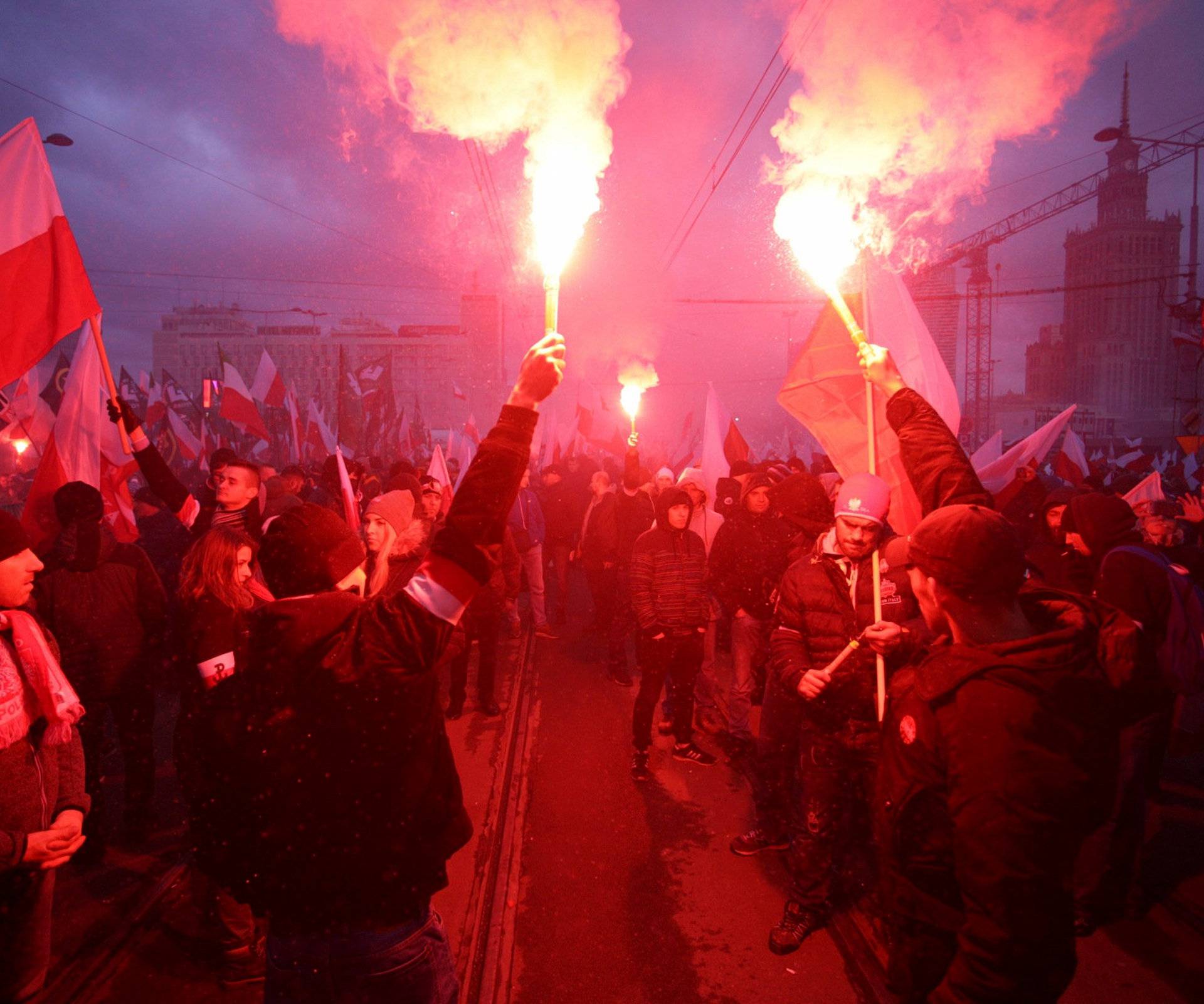 Protesters light flares and carry Polish flags during a rally, organised by far-right, nationalist groups, to mark 99th anniversary of Polish independence in Warsaw