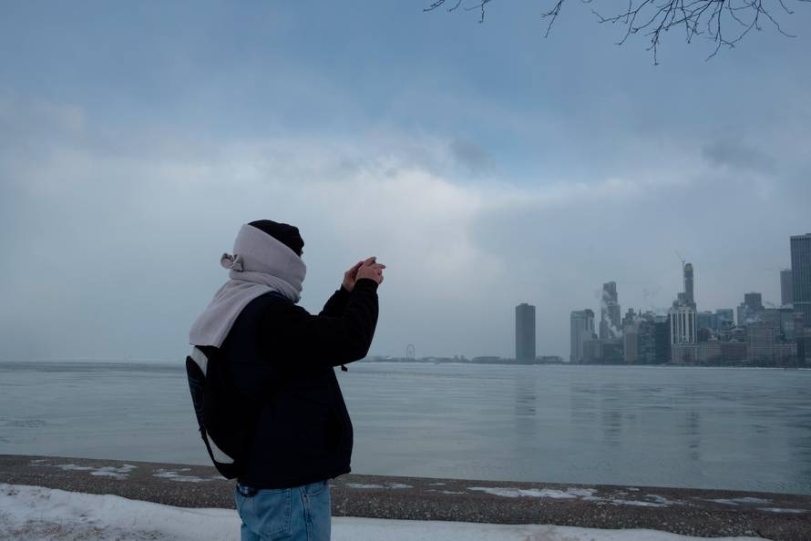 Jim Cleary takes a photo of the city skyline from the North Avenue Beach at Lake Michigan in Chicago