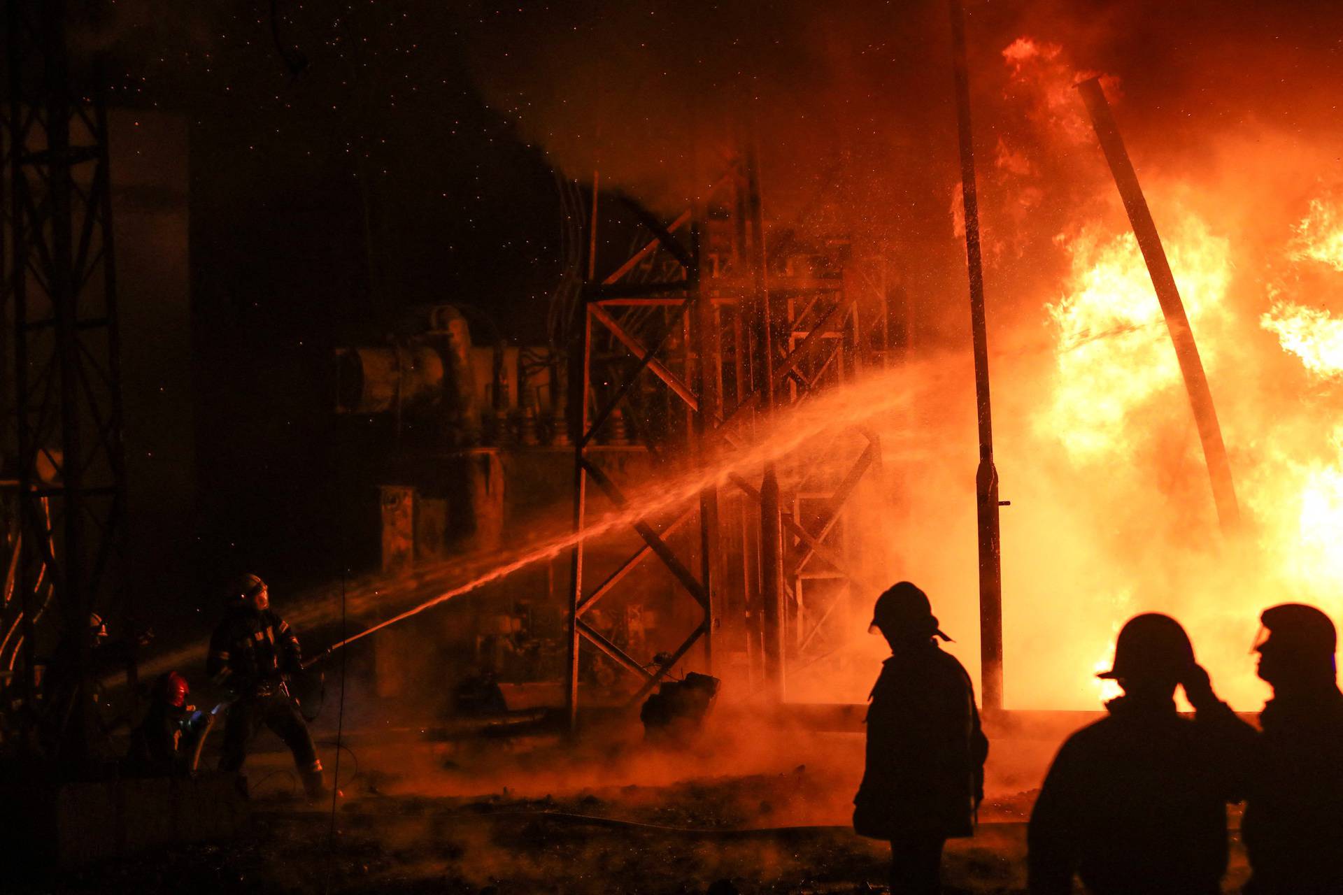 Firefighters work at a site of a thermal power plant damaged by a Russian missile strike in Kharkiv