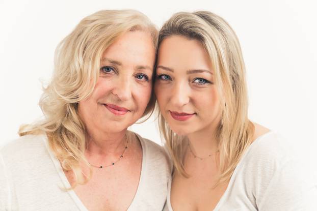 two caucasian women posing and looking at the camera - studio closeup isolated on a white background