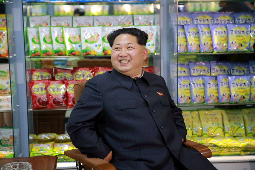 FILE PHOTO: KCNA picture shows North Korean leader Kim Jong Un smiling while sitting during a visit to inspect the Pyongyang Children's Foodstuff Factory