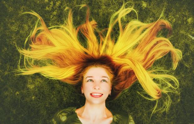 Happy woman with long hair down on grass