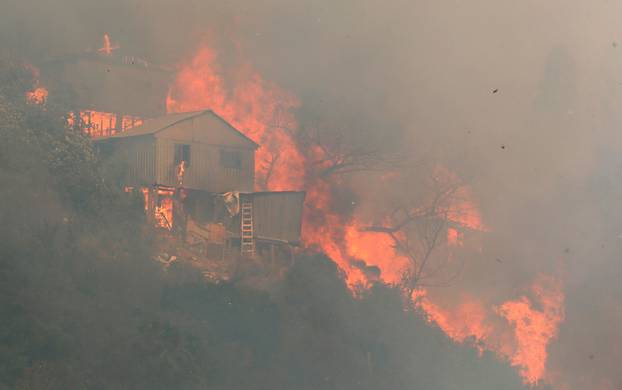 Fire burns a house on a hill, where more than 100 homes were burned due to forest fire but there have been no reports of death, local authorities said in Valparaiso, Chile