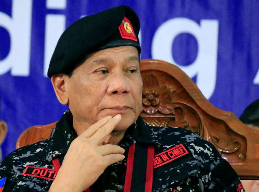 Philippine President Rodrigo Duterte, wearing a military uniform, gestures as he attends the 67th founding anniversary of the First Scout Ranger regiment in San Miguel town, Bulacan province, north of Manila
