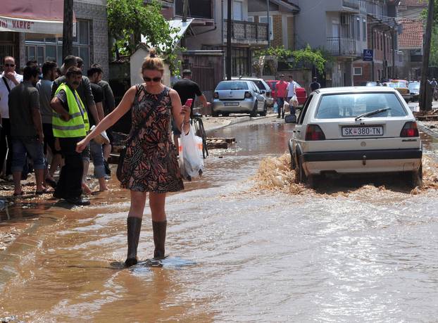 A woman wallks on the street after heavy floods in Cento 