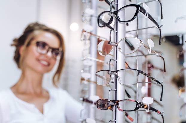 Woman,Selects,Stylish,Glasses,In,Store.,A,Woman,Examines,Various