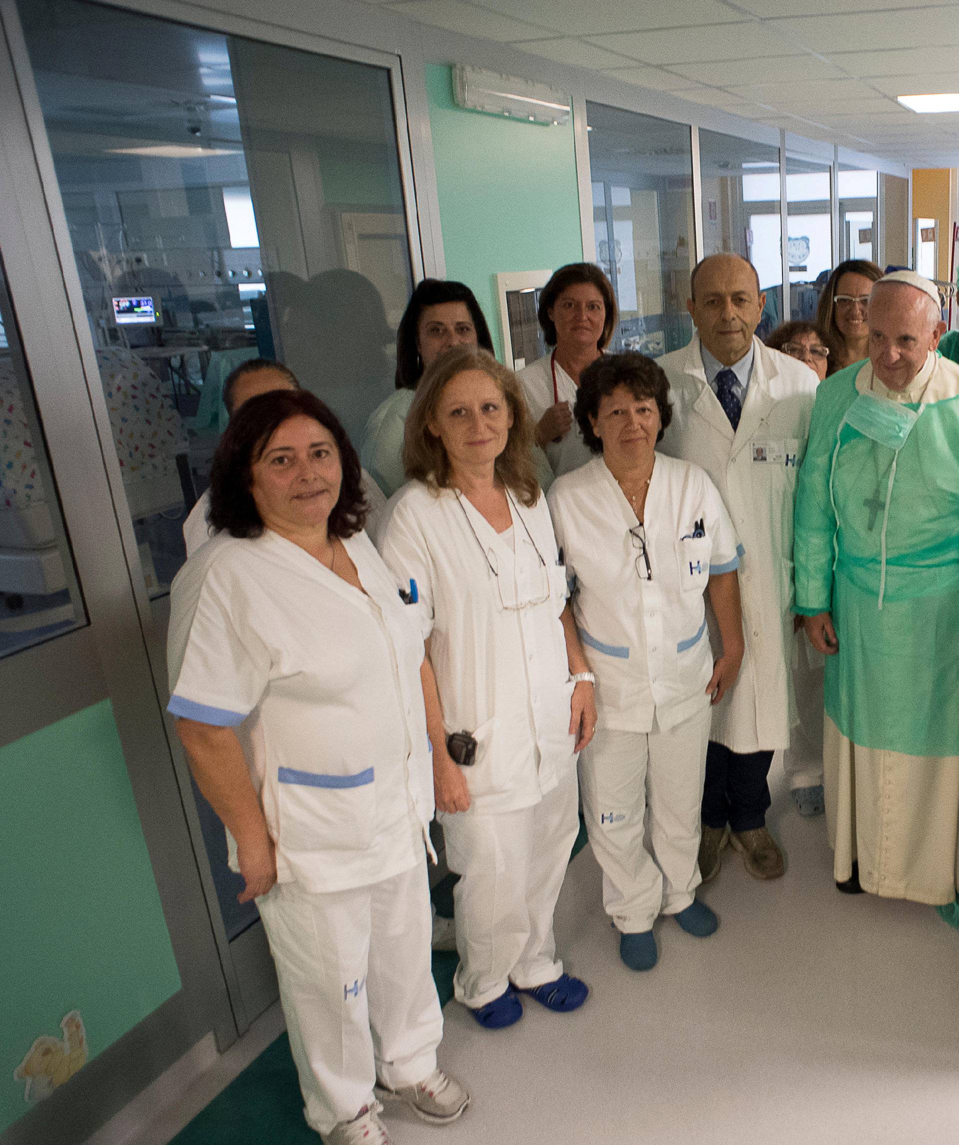 Pope Francis poses with the intensive care nursery staff members at the San Giovanni hospital in Rome