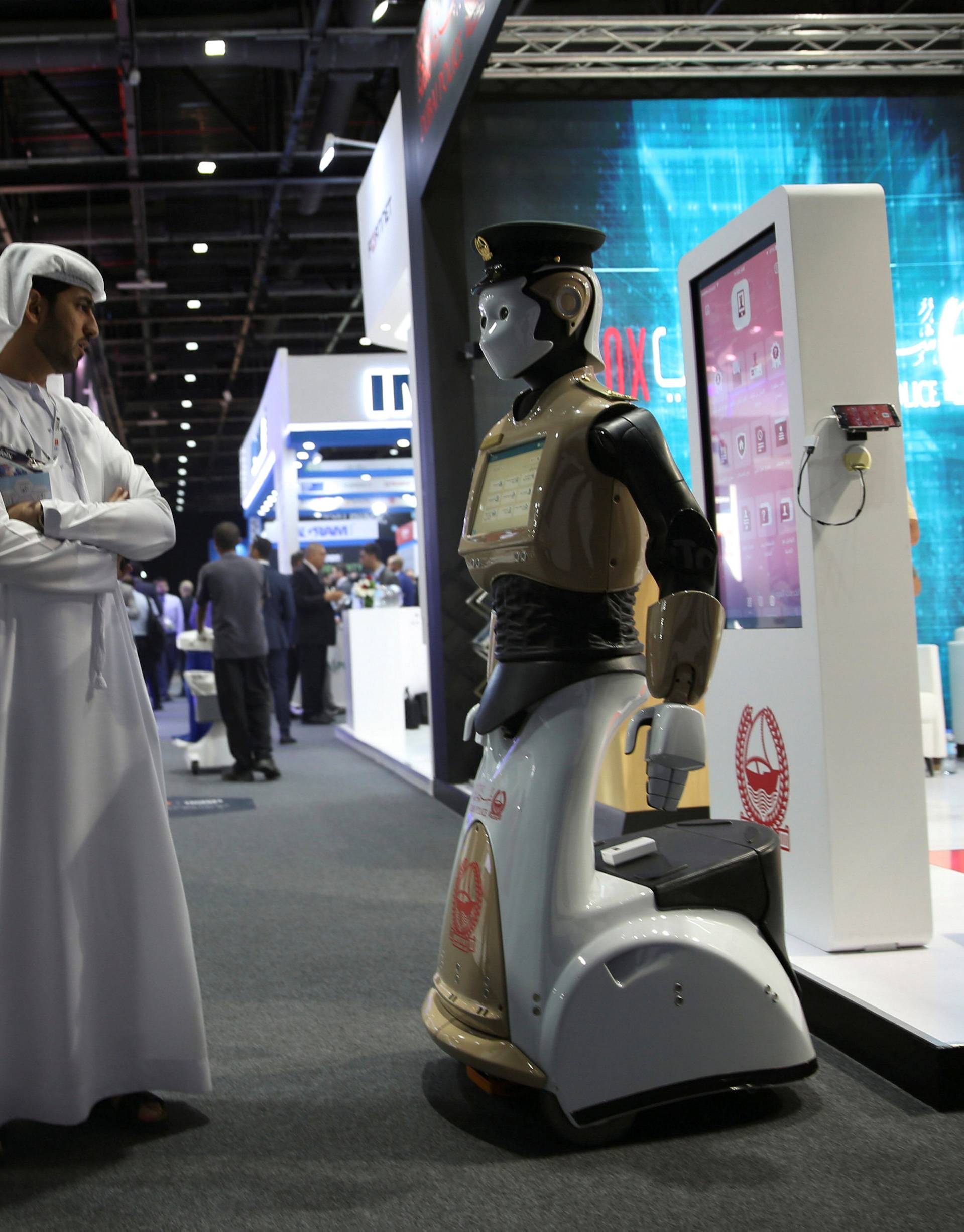 Visitors look at an operational robot policeman at the opening of the 4th Gulf Information Security Expo and Conference (GISEC) in Dubai