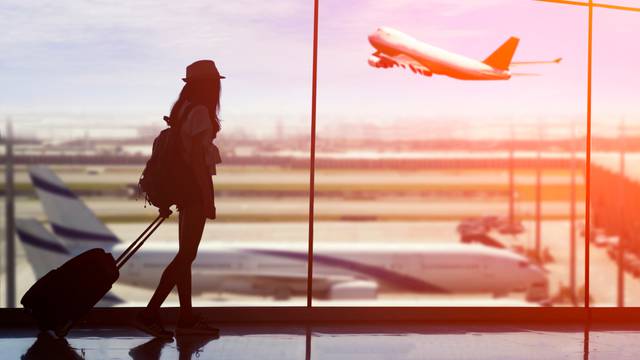 Young,Woman,Is,Standing,Near,Window,At,The,Airport,And