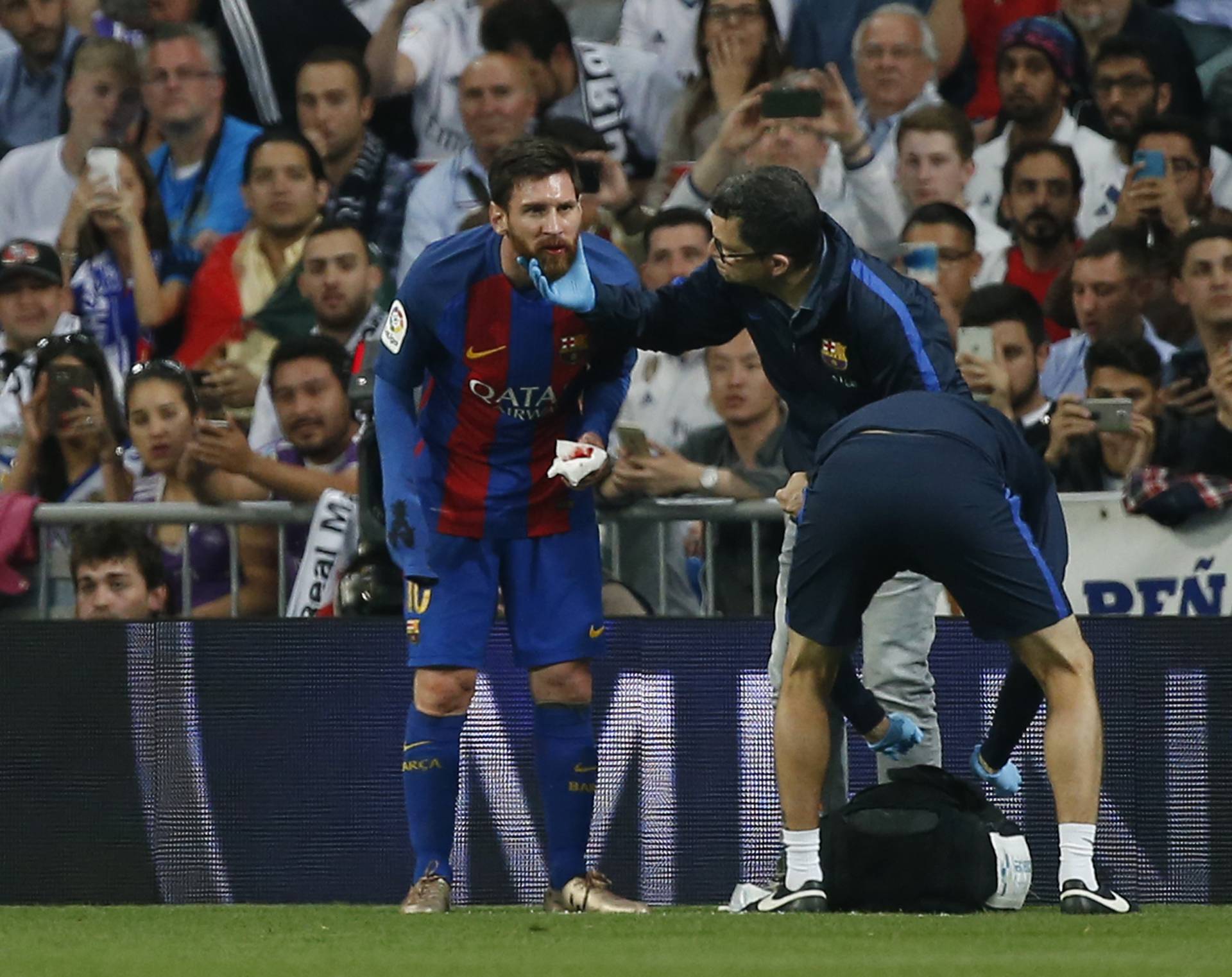 Barcelona's Lionel Messi receives medical attention
