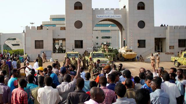 Sudanese demonstrators gather to protest against the army's announcement that President Omar al-Bashir would be replaced by a military-led transitional council, outside the Defence Ministry in Khartoum