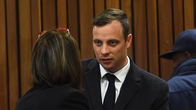 Olympic and Paralympic track star Oscar Pistorius speaks with his lawyer Barry Roux ahead of his sentence hearing at the North Gauteng High Court in Pretoria
