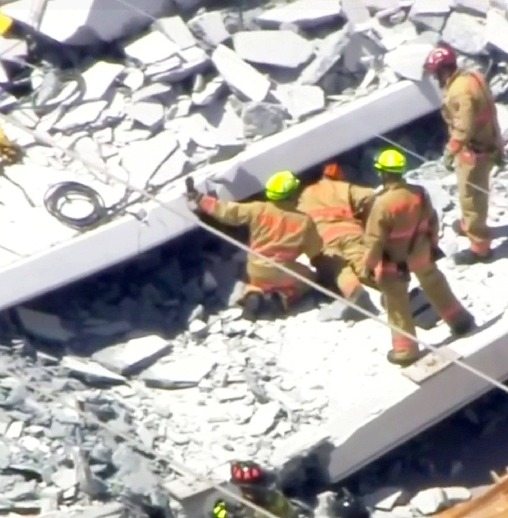 Emergency crews look for victims at the scene of a collapsed pedestrian bridge at Florida International University in Miami, Florida