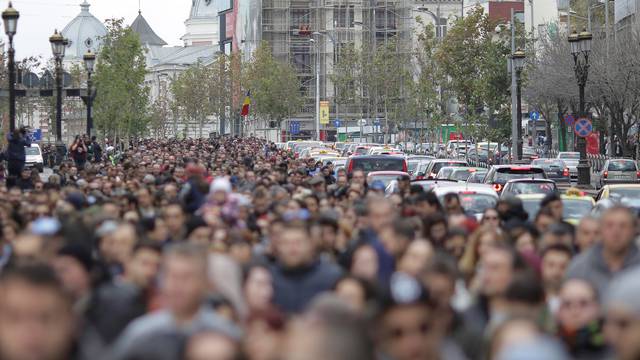 People march on one of the main boulevards of Bucharest during an event that marks one year since a fire at club Colectiv killed 64 people, in Bucharest