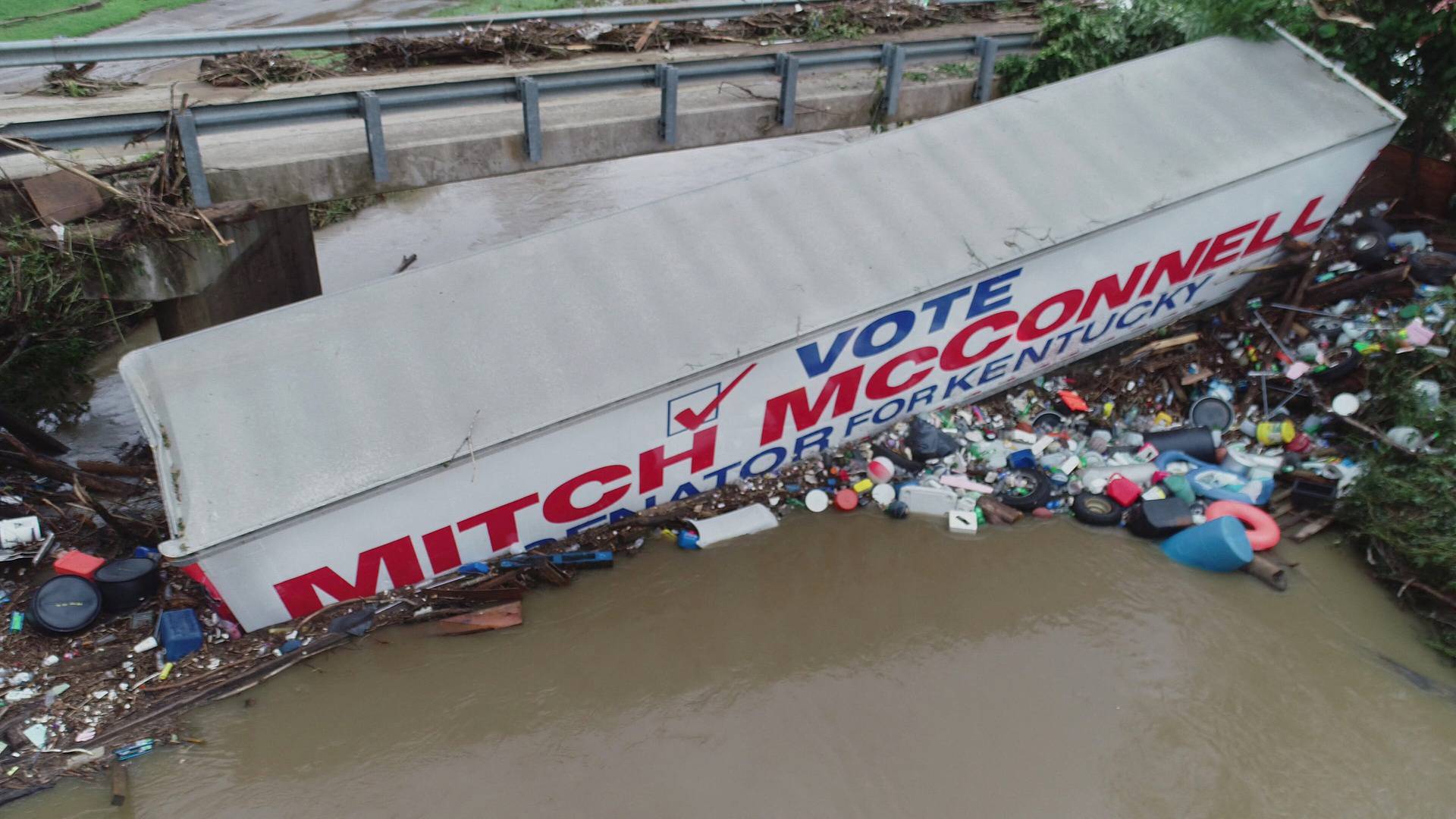 A trailer promoting U.S. Senate Republican leader Mitch McConnell lies in a waterway due to flooding in eastern Kentucky