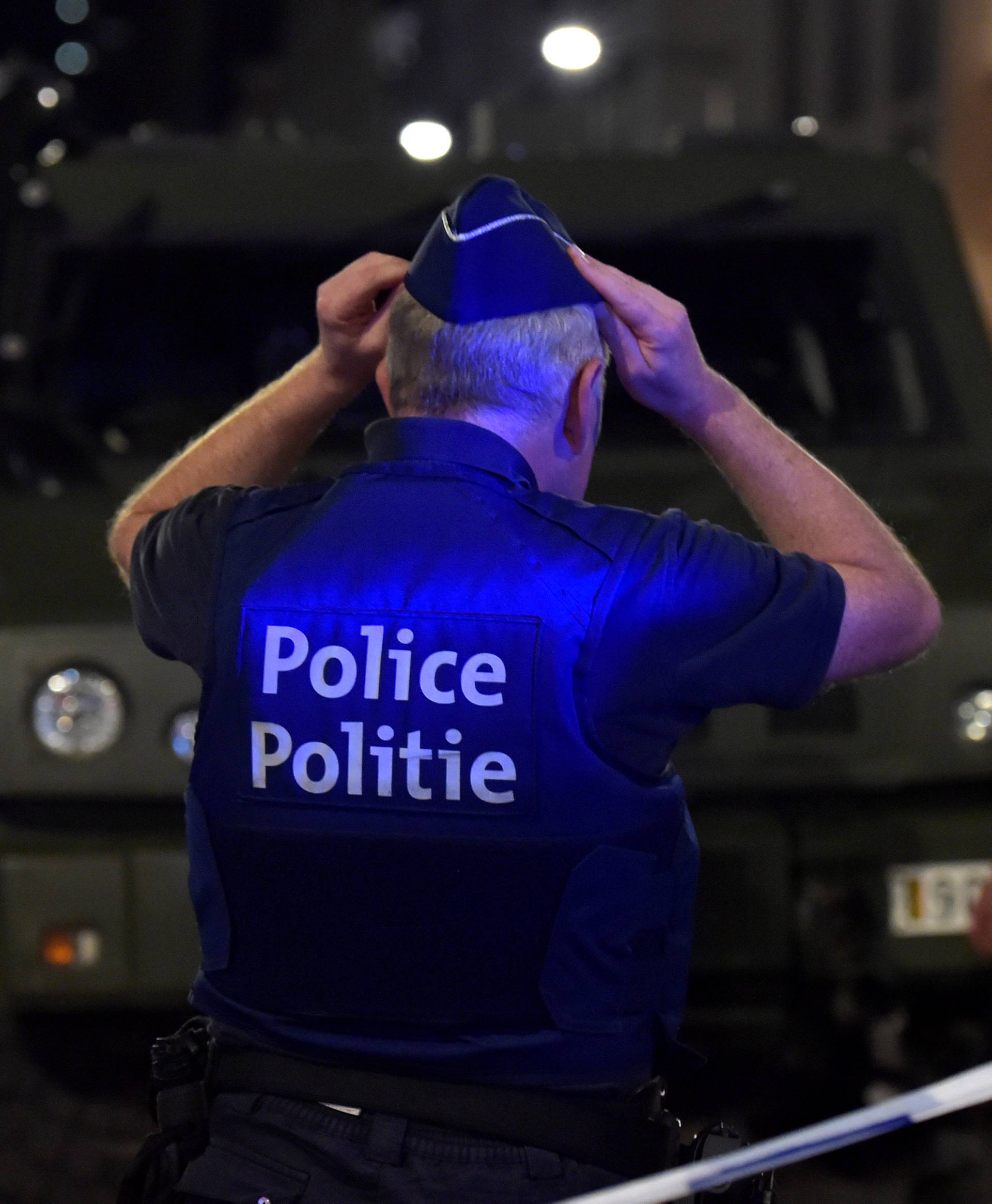 A policeman reacts on the scene after Belgian soldiers shot a man who attacked them with a knife, in Brussels