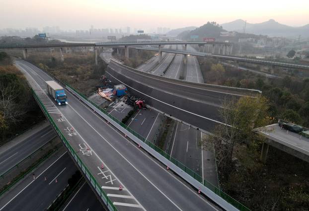 Overturned vehicles are seen at the site where a highway flyover collapsed in Ezhou