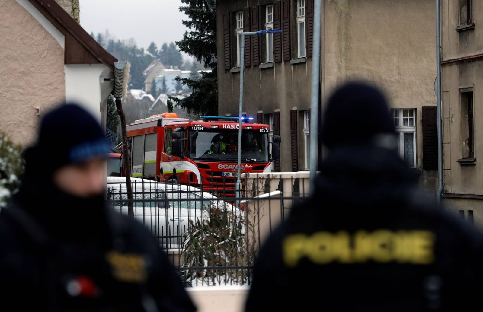 Police officers and a firefighter truck are seen next to a home for people with disabilities which was affected by a fire, in Vejprty