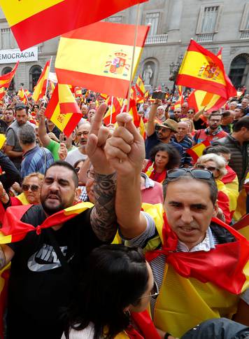 People shout and hold up Spanish flags during a demonstration in favor of a unified Spain a day before the banned October 1 independence referendum, in Barcelona