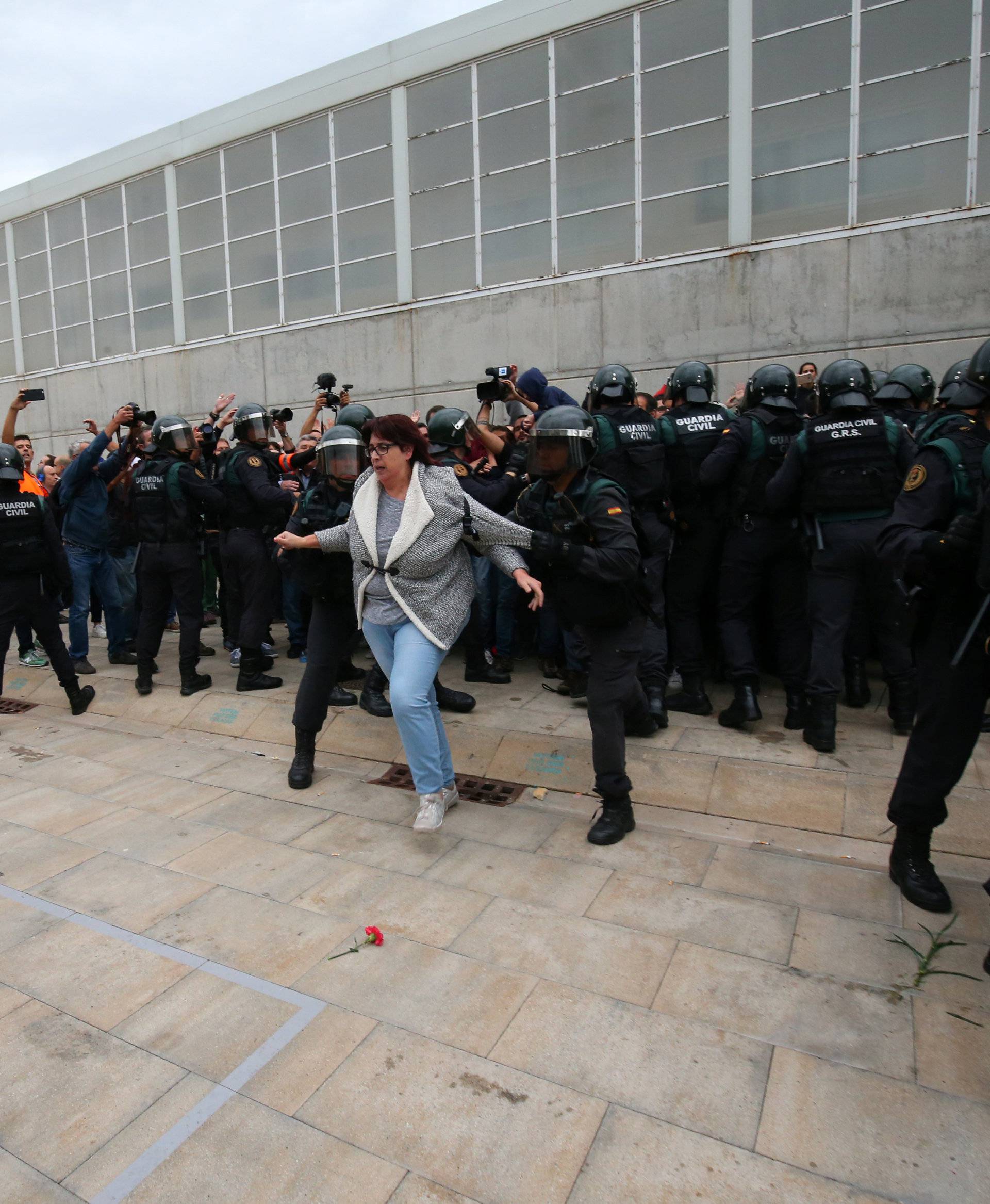 A woman is pushed away by Spanish Civil Guard officers outside a polling station for the banned independence referendum in Sant Julia de Ramis