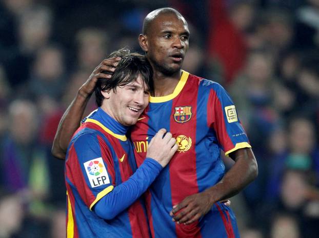 FILE PHOTO: Barcelona defender Abidal embraces teammate Messi after a goal against Atletico Madrid during their Spanish first division soccer match in Barcelona