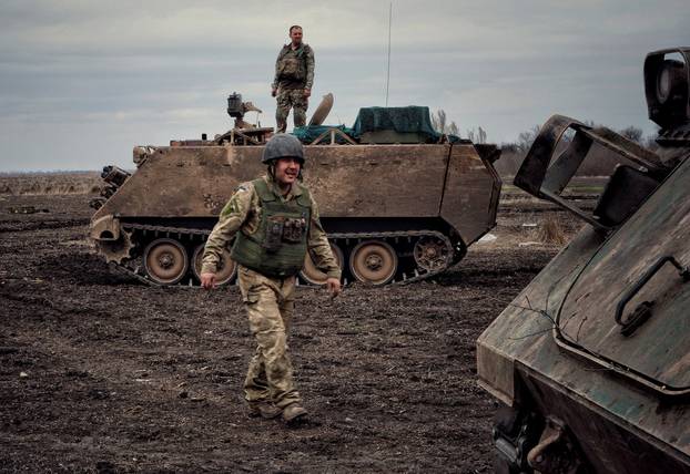 A Ukrainian serviceman walks near at M113 Armoured Personnel Carrier in Donbas region