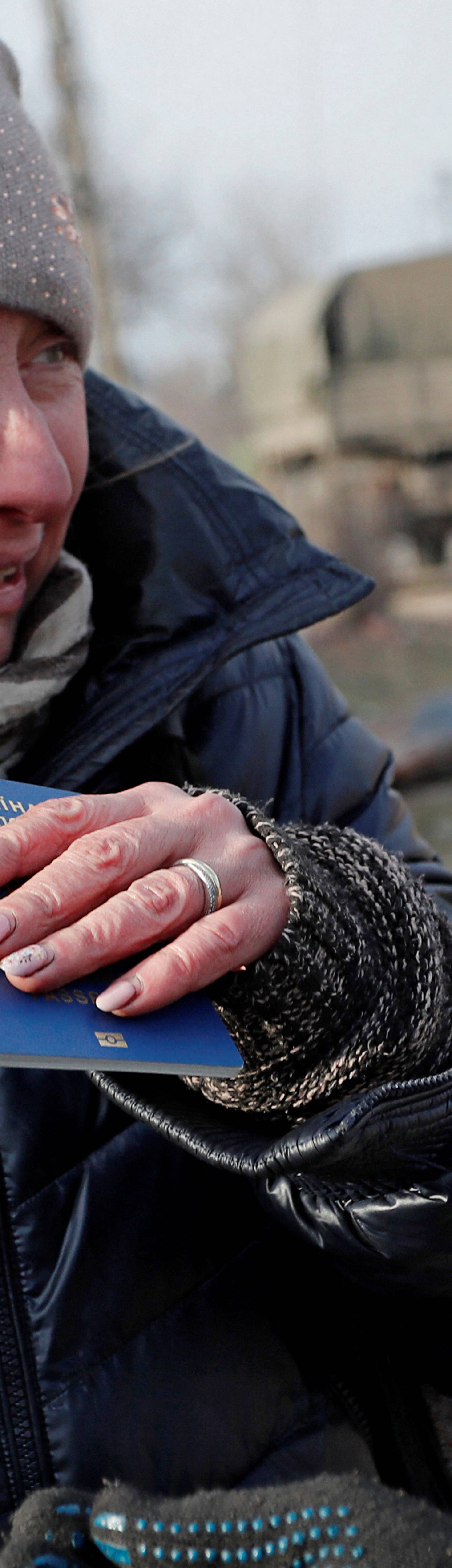 Local resident Inga Serbina holds her passport before leaving the besieged city of Mariupol