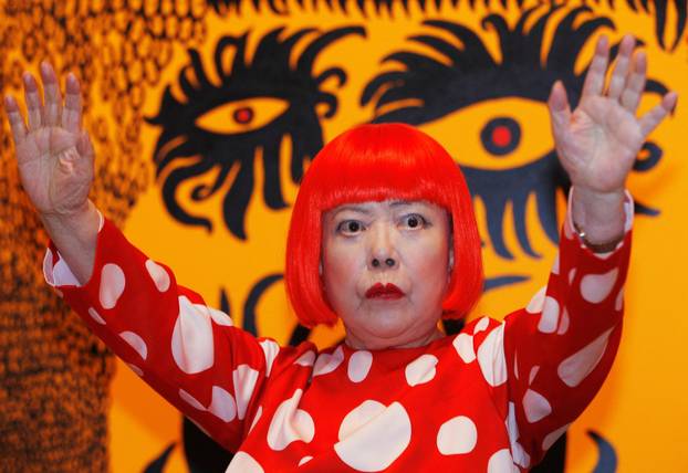 FILE PHOTO: Artist Yayoi Kusama poses for a photograph with a detail from her artwork "Love arrives at the Earth Carrying with it a Tale of the Cosmos" at the Tate Modern gallery in London