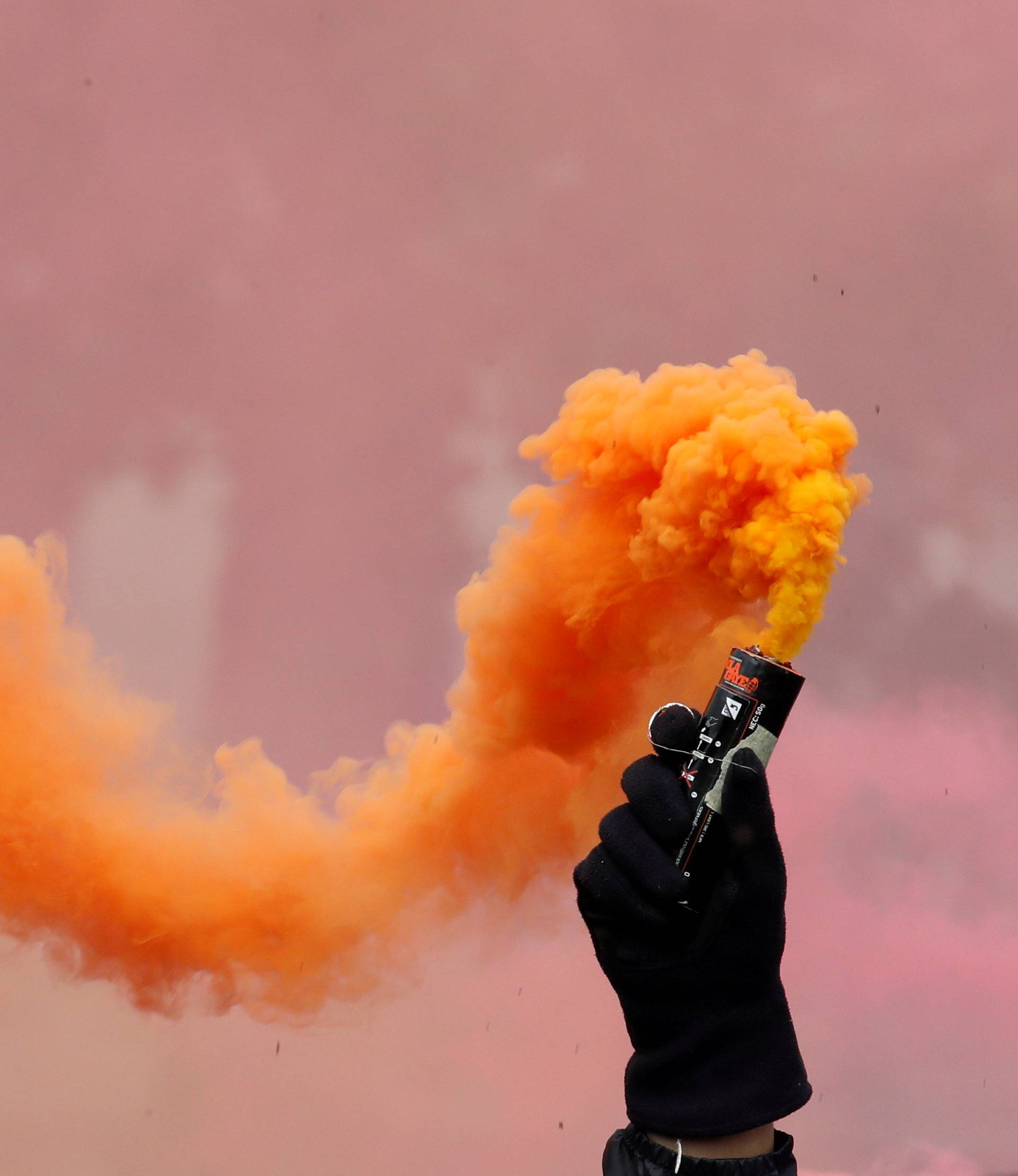 Protester holds a smoke safety flare during the May Day labour union march in Paris
