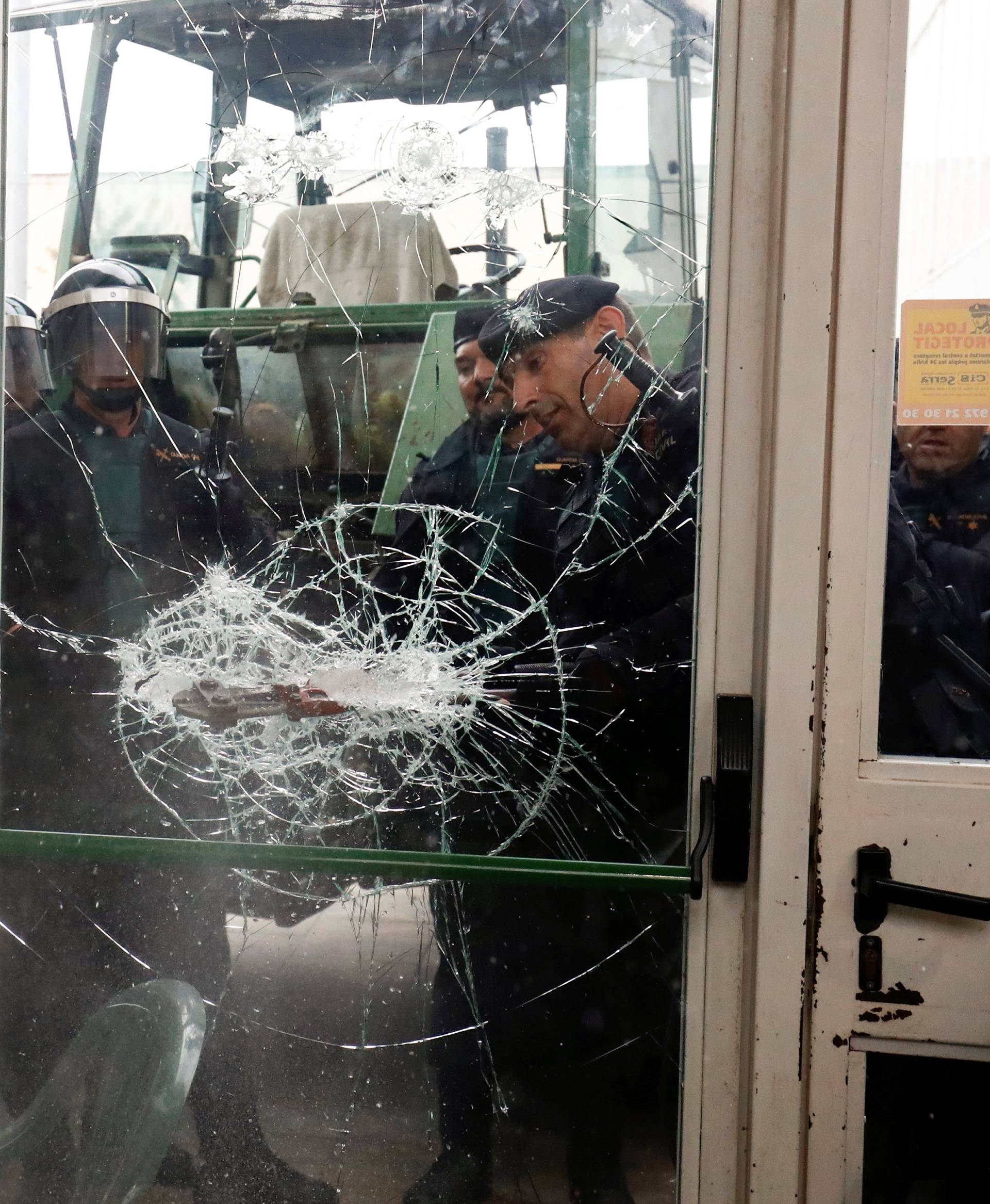 Spanish Civil Guard officers break through a door at a polling station for the banned independence referendum where Catalan President Puigdemont was supposed to vote in Sant Julia de Ramis