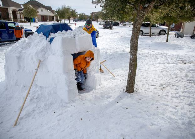 Brett Archibad helps his son build an Igloo as his son Avett Archibad ,8, peeks out of the Igloo in their front yard of their home in the BlackHawk neighborhood in Pflugerville