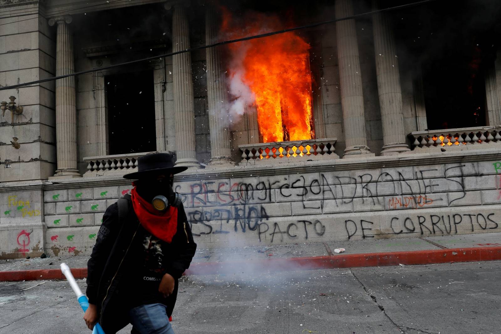 Demonstrators are seen after setting on fire an office of the Congress building during a protest demanding the resignation of President Alejandro Giammattei, in Guatemala City