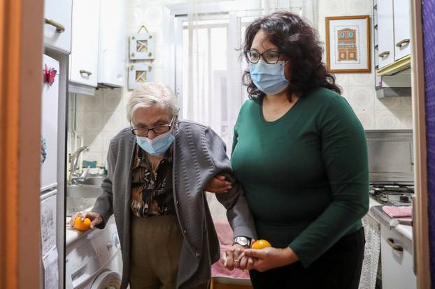 Florentina Martin, a 99 year-old woman who survived coronavirus disease (COVID-19), is helped by her caregiver Olga Arauz in her home in Pinto