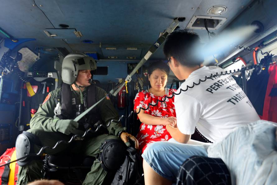 Evacuees are airlifted in a U.S. Coast Guard helicopter after flooding due to Hurricane Harvey inundated neighborhoods in Houston