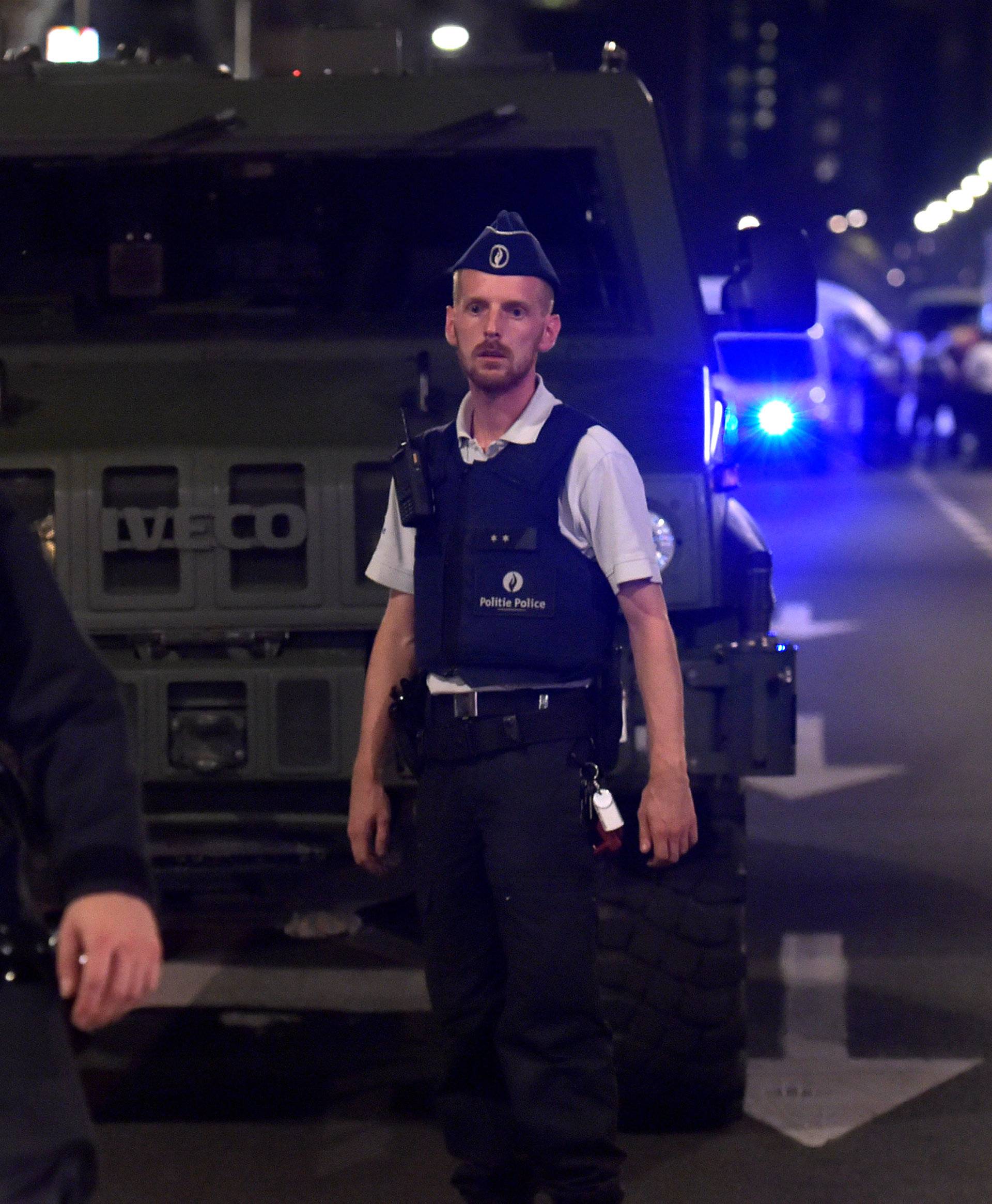 Policemen react on the scene after Belgian soldiers shot a man who attacked them with a knife, in Brussels