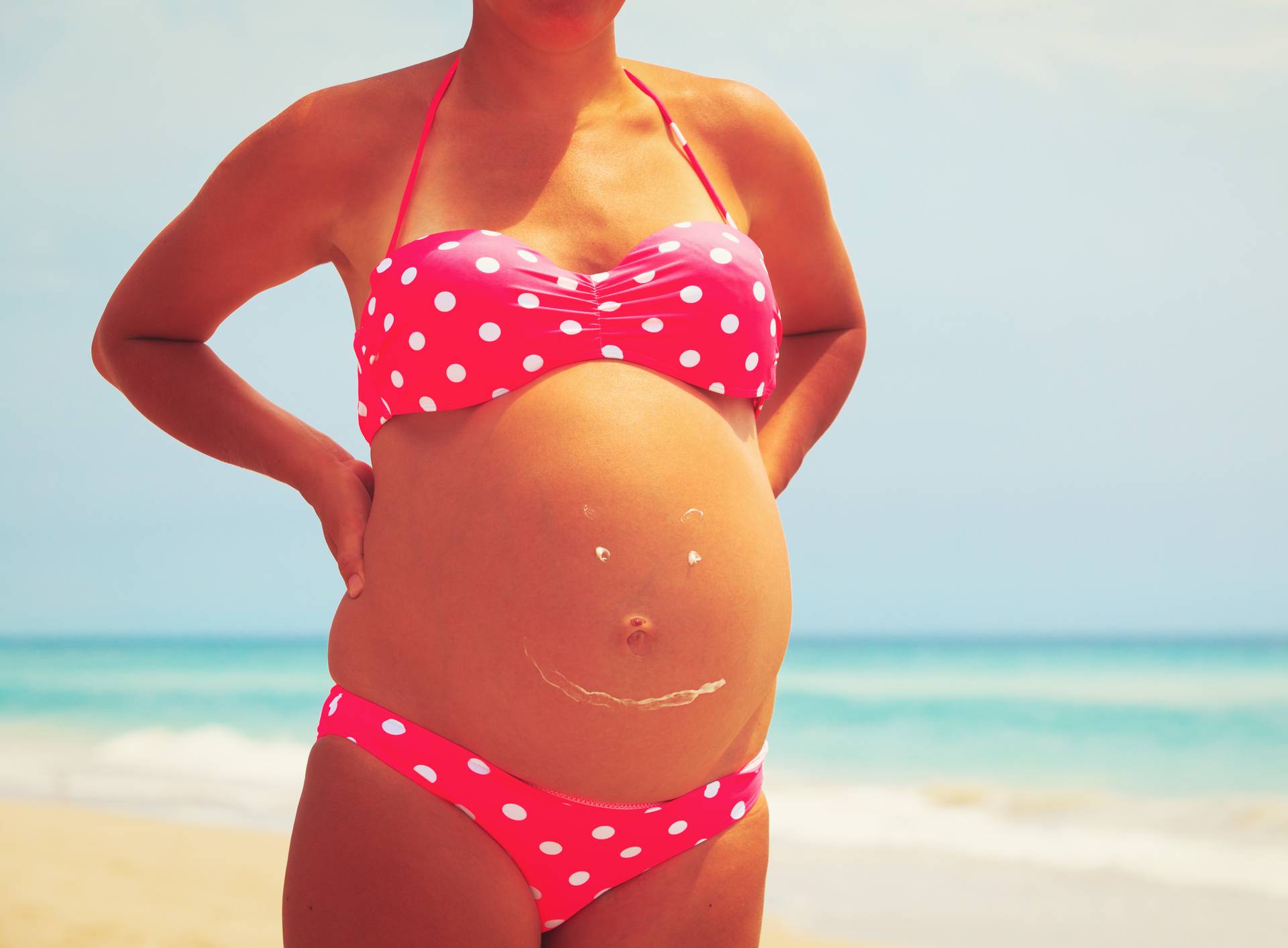 Happy pregnant woman at beach