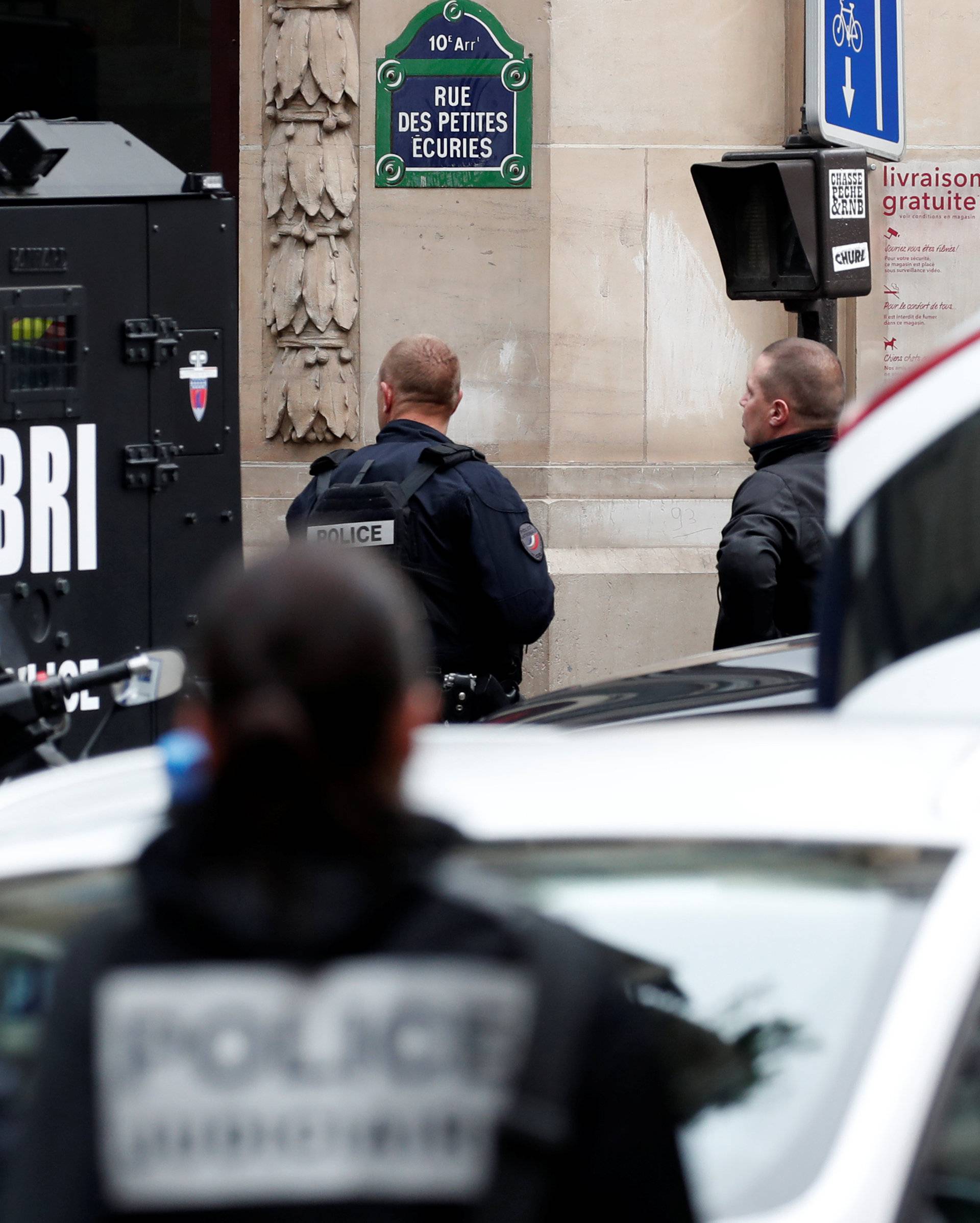 French police and special police forces (BRI) secure the street as a man has taken people hostage at a business in Paris