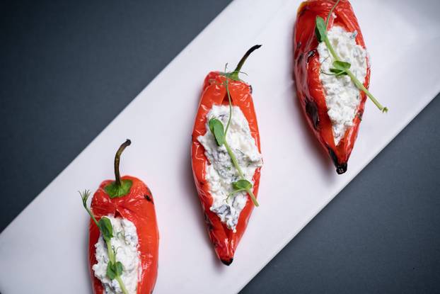 top view of bulgarian peppers stuffed with cottage cheese on black background