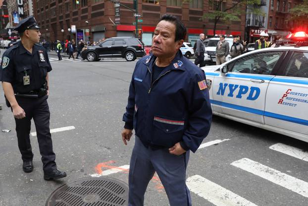A postal employee stands on the street following a report of a suspicious package in the Manhattan borough of New York