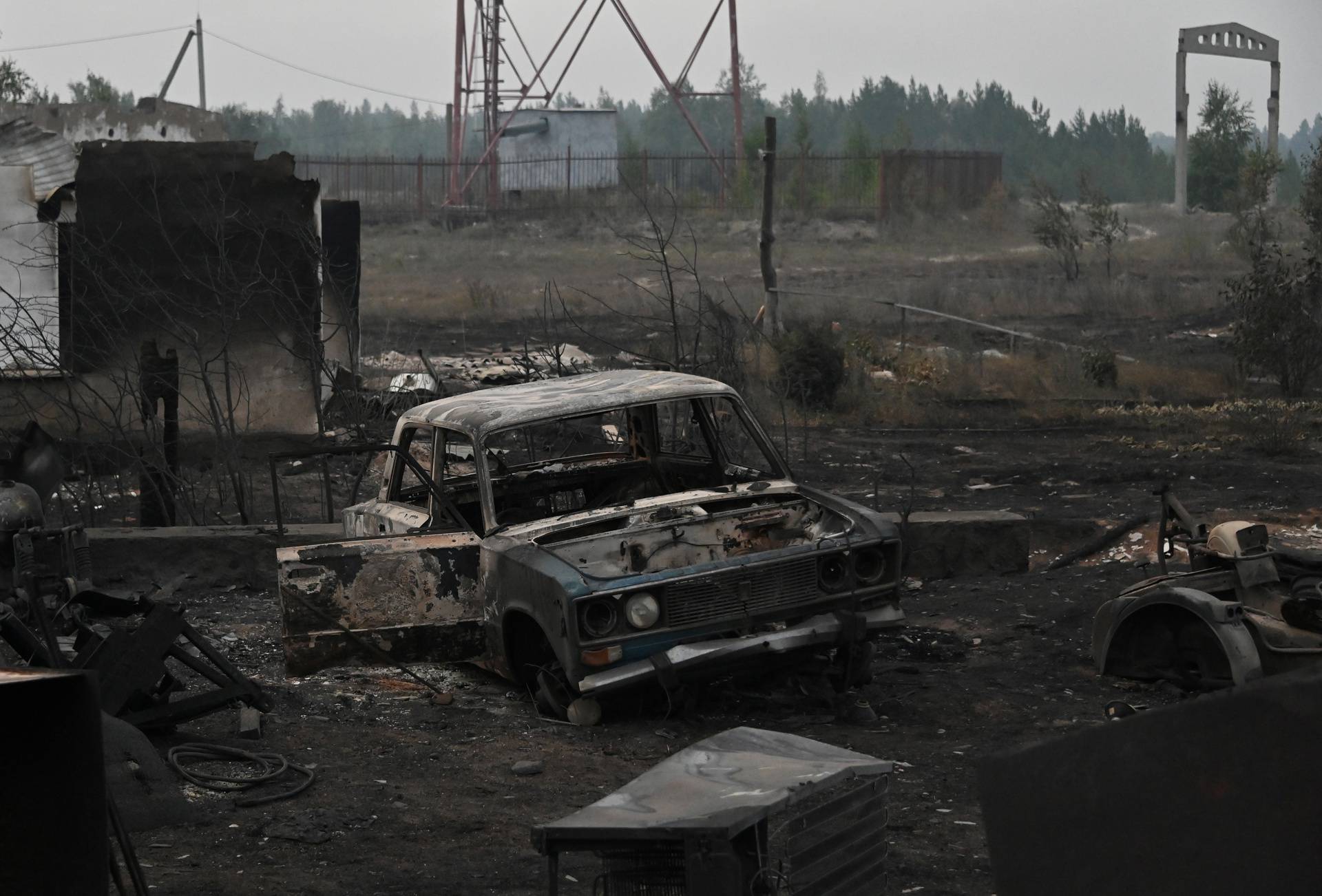 A car burned by flames from a forest fire is seen in Dzhabyk