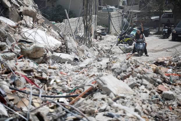 People gather at the site of an Israeli strike carried out before a 10-day ceasefire between Lebanon and Israel went into effect, in Tyre