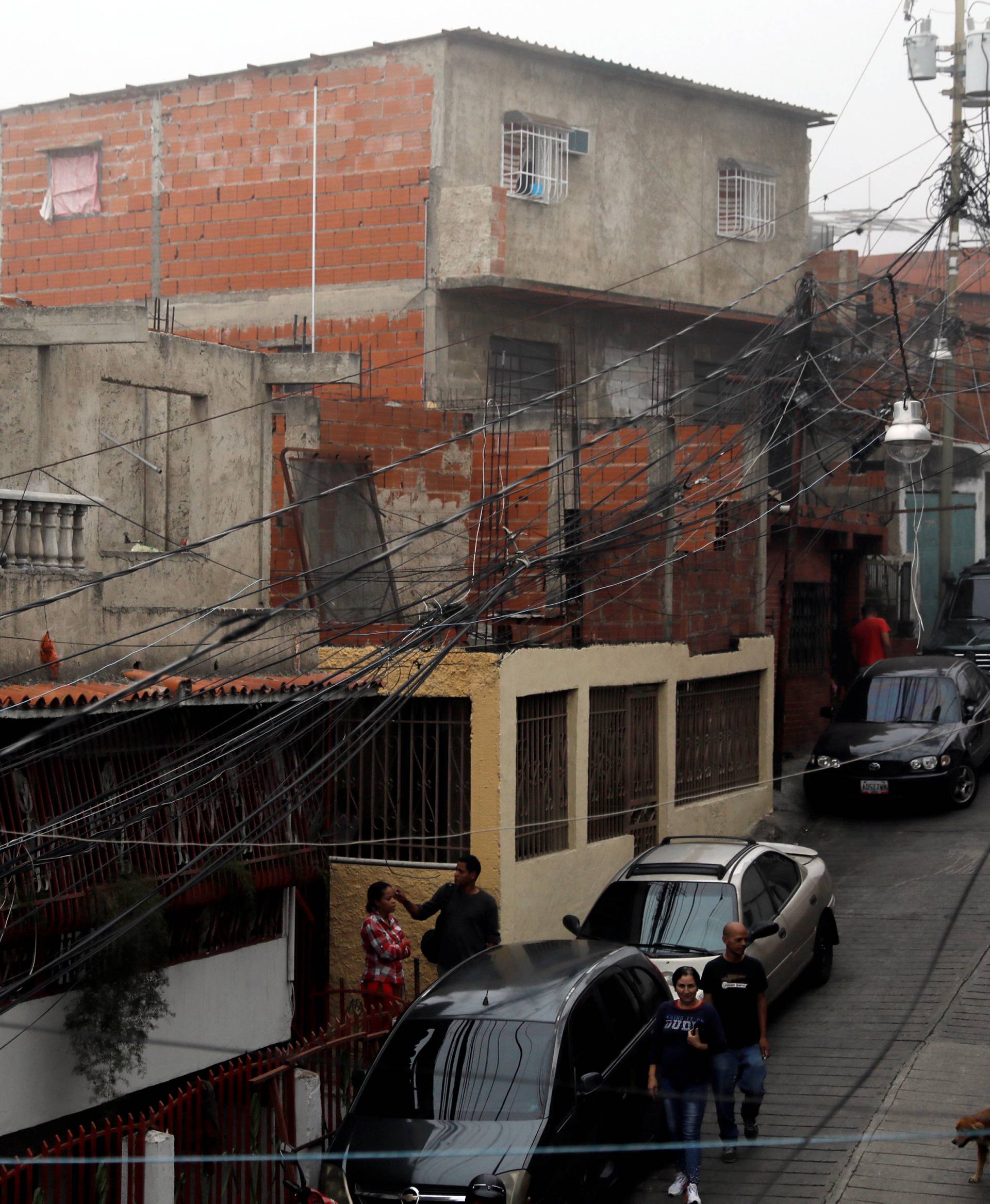 Electrical cables are seen dangling above a street during a blackout in Catia slum in Caracas