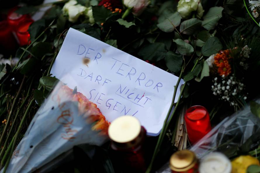 Flowers, candles and a note saying "The terror can not prevail" are placed near the Christmas market in Berlin