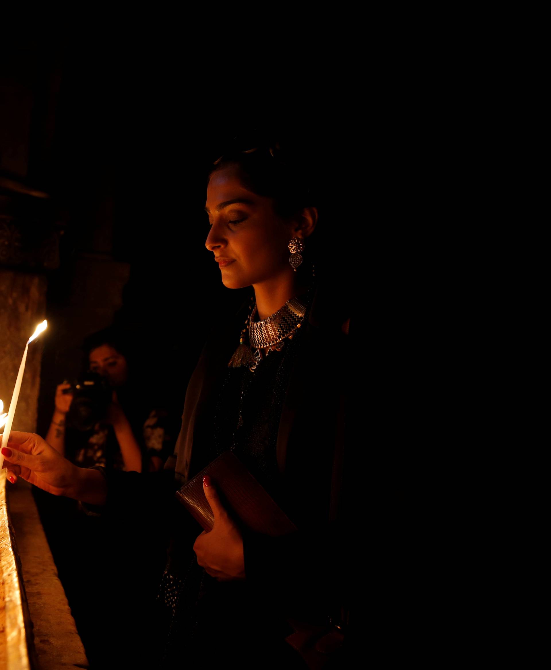 Indian actress Sonam Kapoor lights a candle during her visit to the Church of the Holy Sepulchre in Jerusalem's Old City 